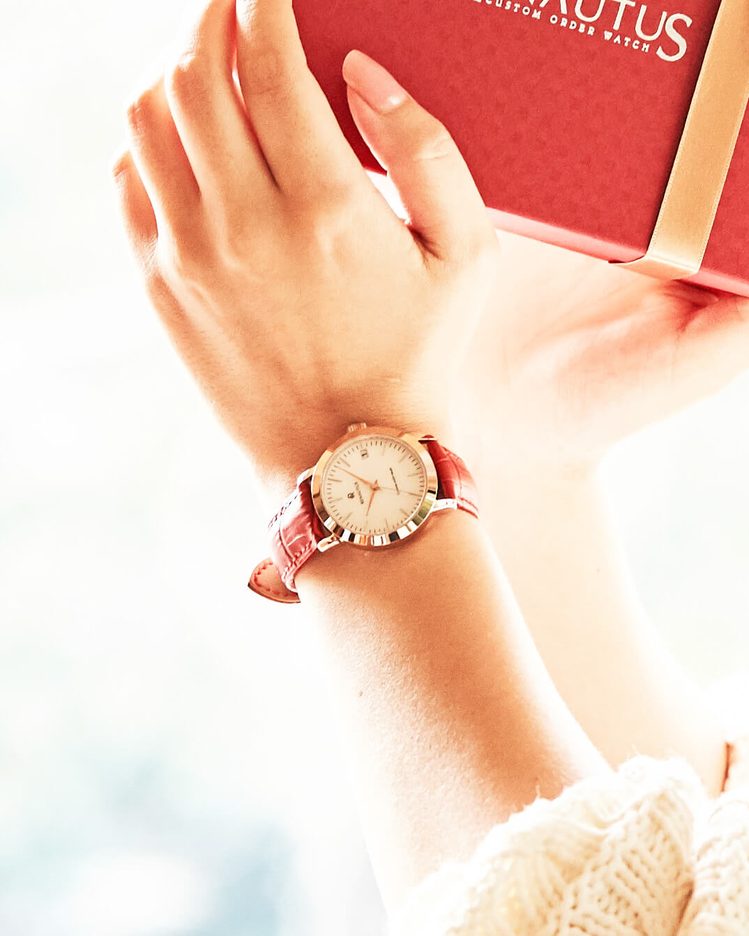 赤い革ベルトのクオーツ式腕時計をしている女性